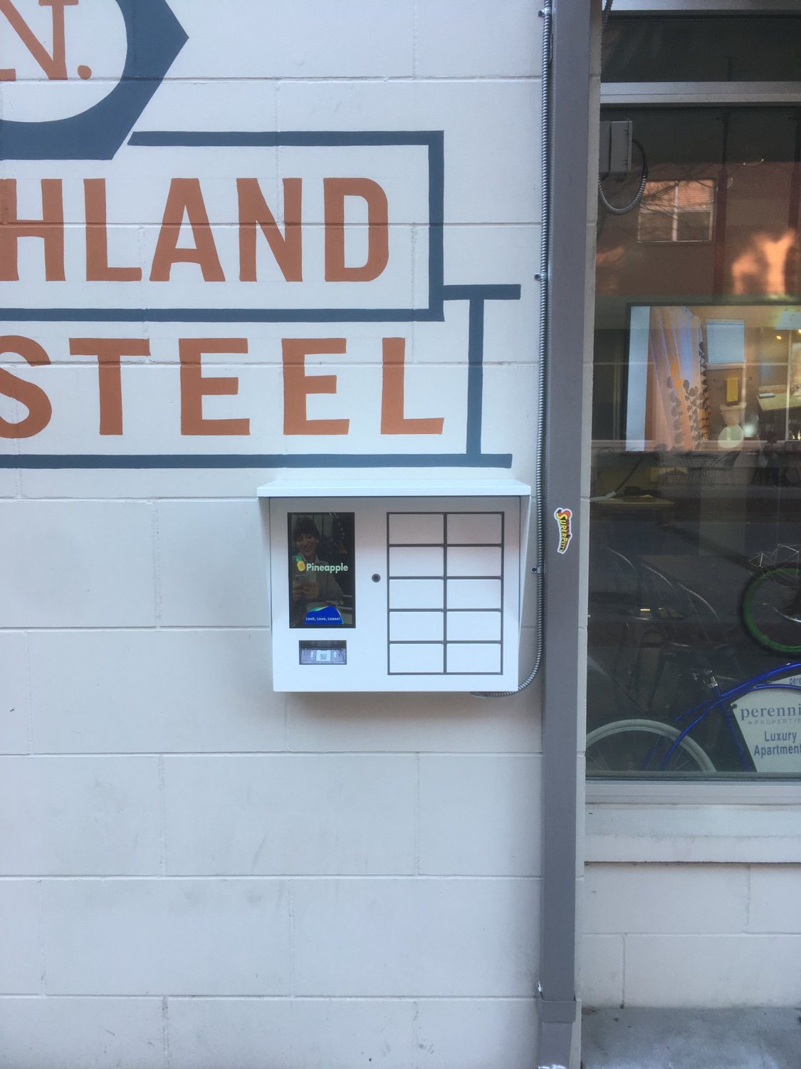The original white Pineapple kiosk mounted on the wall at N. Highland Steel